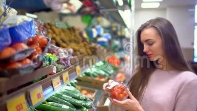 超市里的女人选择超市里的西红柿选择蔬菜。